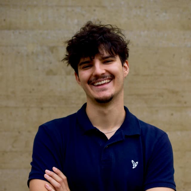 CTO portrait, arms crossed, smiling, in front of a concrete wall.