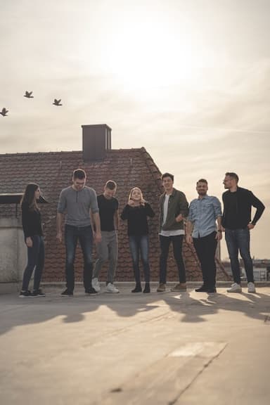 aclipp team standing on a rooftop at sunset; several birds flying in the background.